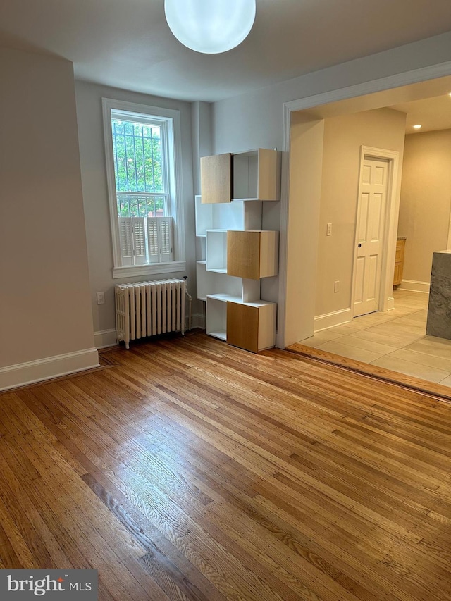 interior space with light wood-style flooring, radiator heating unit, and baseboards