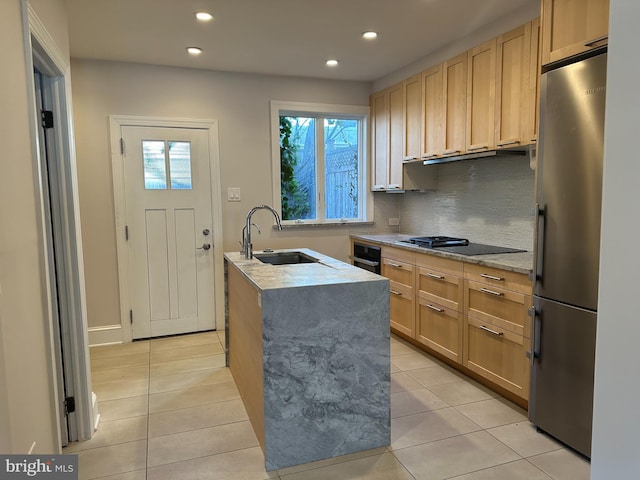 kitchen featuring light stone counters, light brown cabinets, a sink, black appliances, and backsplash