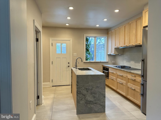 kitchen with a sink, black appliances, light tile patterned flooring, and light brown cabinets