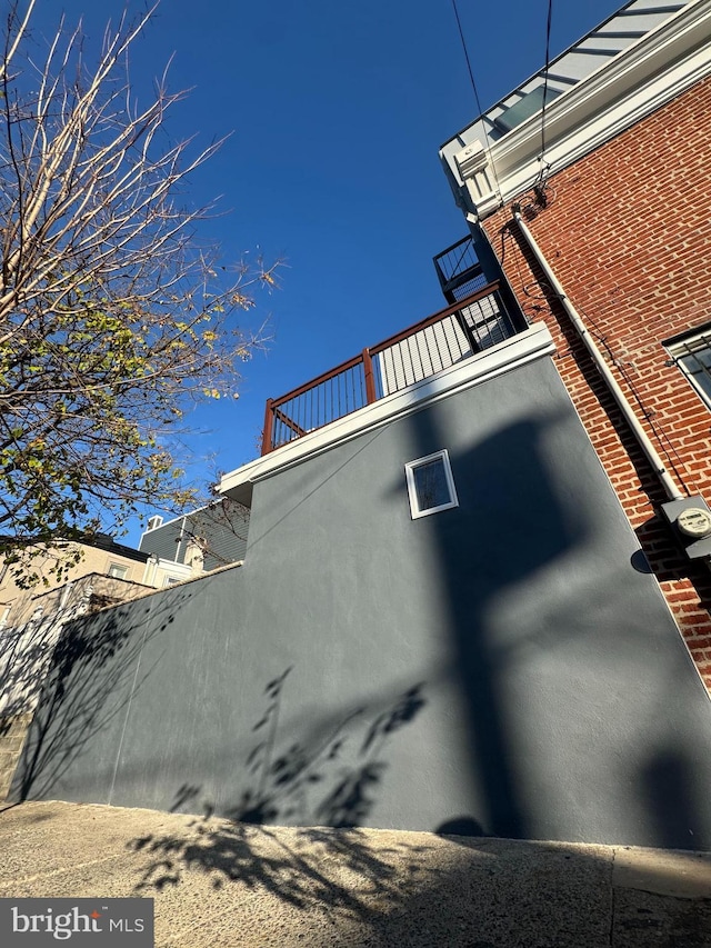 view of home's exterior featuring a balcony and fence