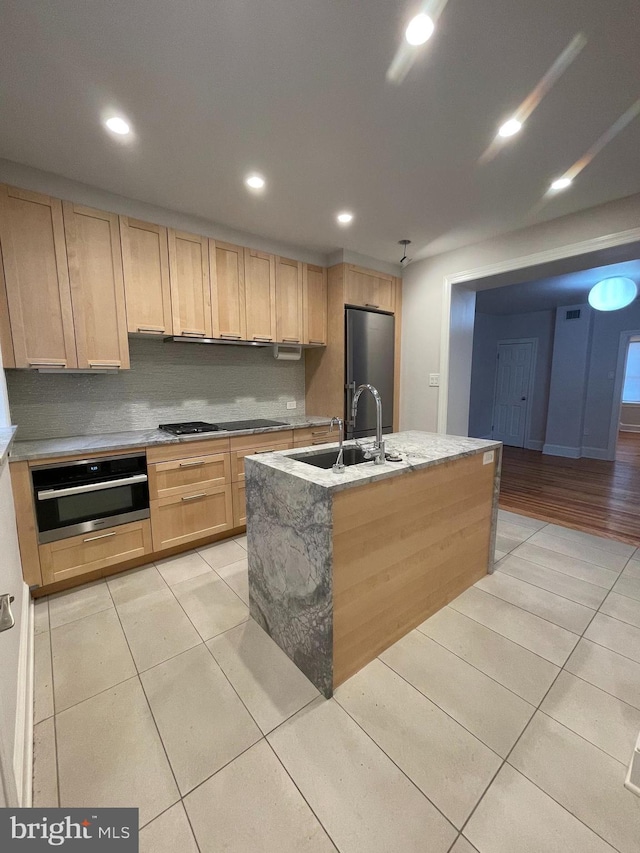 kitchen with light brown cabinets, light tile patterned floors, recessed lighting, stainless steel appliances, and a sink