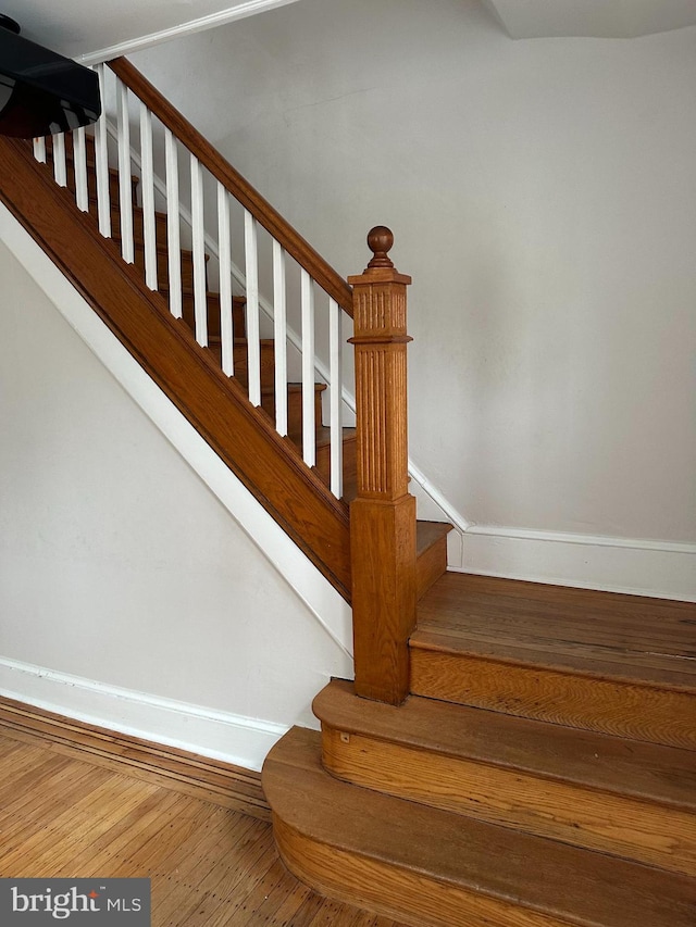 stairs with baseboards and wood finished floors