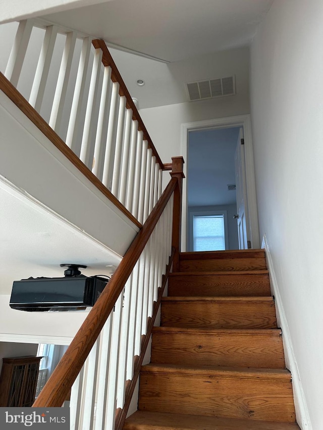 stairway with visible vents and baseboards