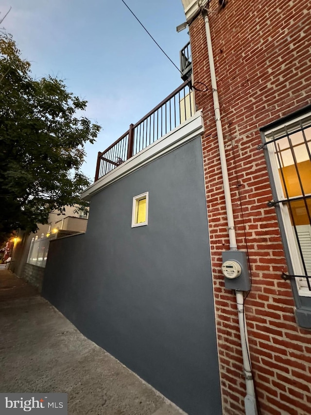 view of home's exterior featuring brick siding and a balcony