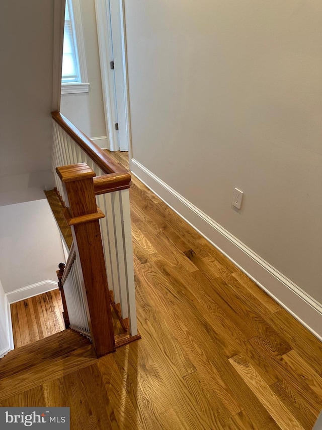 stairway with baseboards and wood finished floors