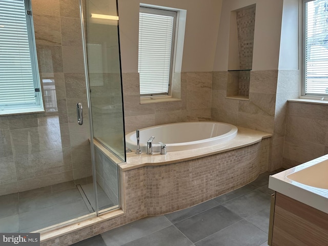 full bathroom featuring tile patterned flooring, a stall shower, tile walls, and a garden tub