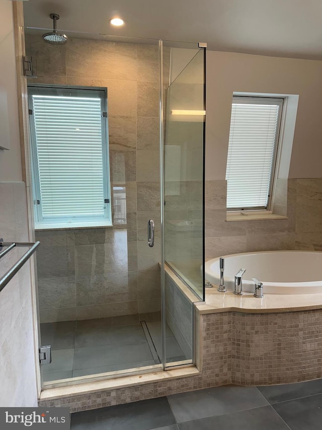 bathroom with a garden tub, tile patterned floors, and a shower stall