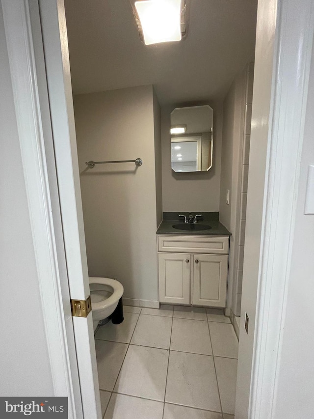 bathroom with tile patterned flooring, toilet, vanity, and baseboards