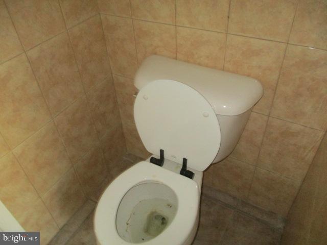 bathroom featuring tile walls, toilet, and tile patterned floors