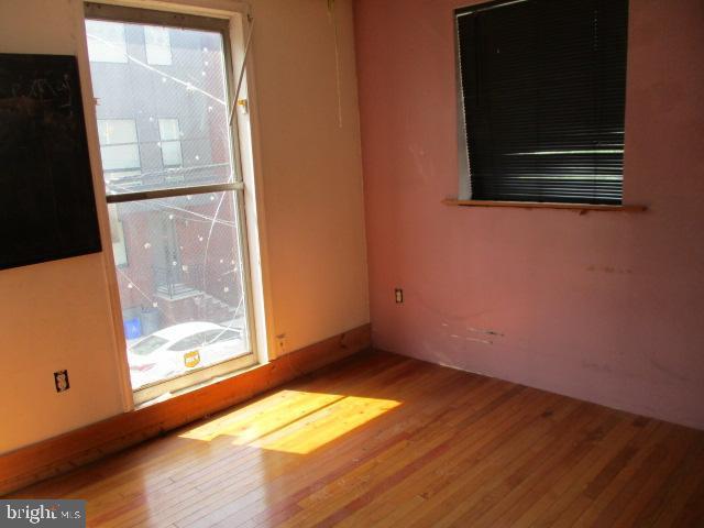 unfurnished room with hardwood / wood-style flooring