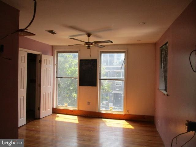 empty room with hardwood / wood-style floors and ceiling fan