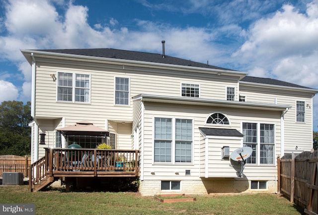 rear view of property with a yard, a wooden deck, and central AC unit