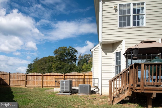 view of yard with central air condition unit and a deck