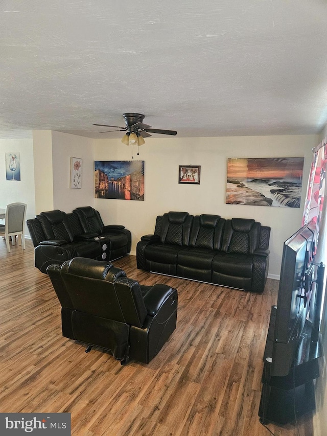 living room with a textured ceiling, ceiling fan, and hardwood / wood-style floors