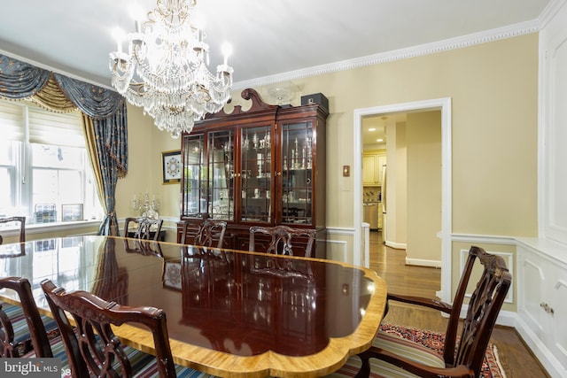 dining room with crown molding, hardwood / wood-style flooring, and a chandelier