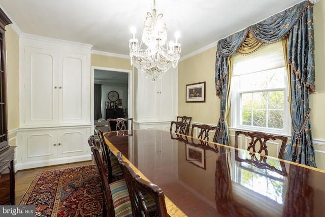 dining room featuring ornamental molding, a notable chandelier, and light wood-style floors