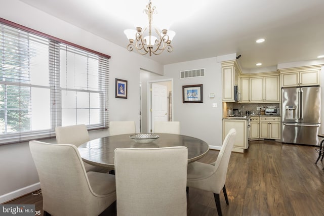 dining space with dark wood-style floors, baseboards, visible vents, and an inviting chandelier