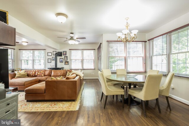 dining space with ceiling fan with notable chandelier and dark wood-type flooring