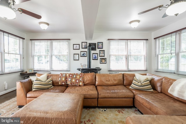 living room featuring a wood stove, light hardwood / wood-style flooring, and ceiling fan