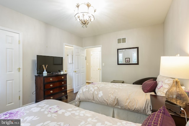 bedroom with an inviting chandelier and hardwood / wood-style flooring