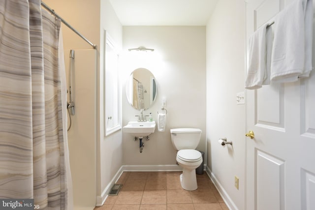 bathroom featuring curtained shower, tile patterned flooring, toilet, and sink