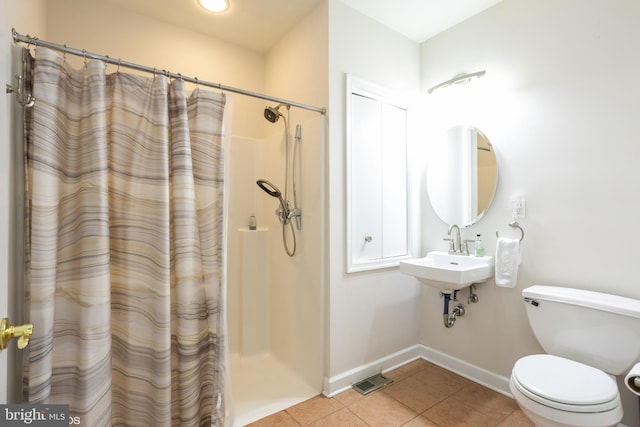 bathroom featuring toilet, sink, tile patterned floors, and walk in shower