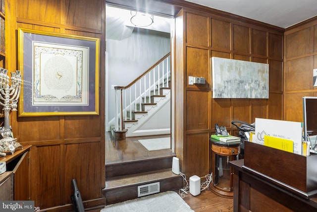 interior space featuring hardwood / wood-style floors and wooden walls