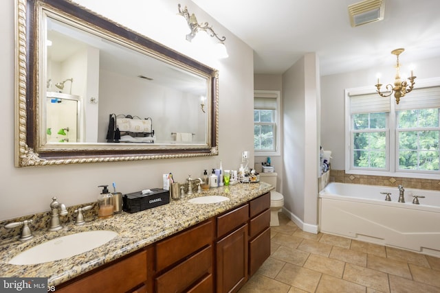 bathroom featuring tile patterned floors, toilet, a notable chandelier, a washtub, and vanity