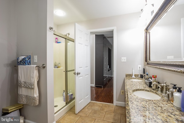 bathroom featuring a stall shower, tile patterned flooring, and a sink