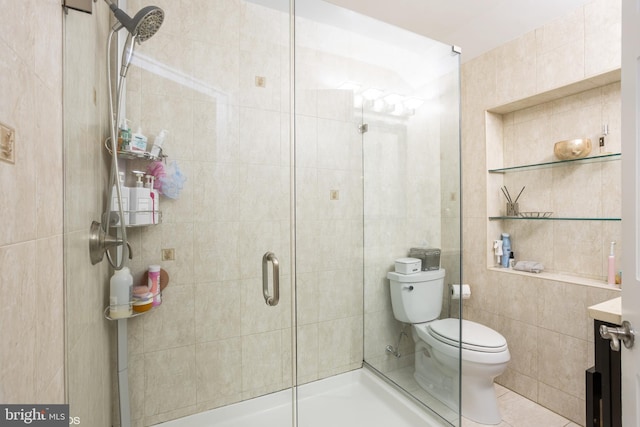 full bathroom featuring toilet, a shower stall, tile walls, and vanity