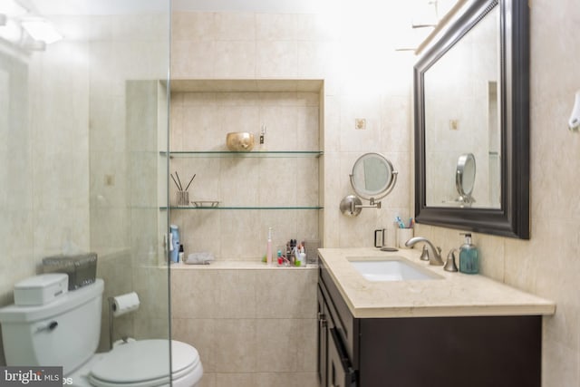 bathroom with tile walls, toilet, and vanity