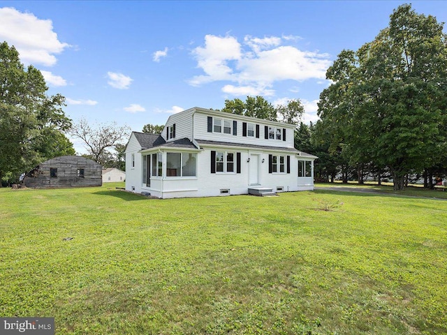 view of front of property with a storage unit and a front yard