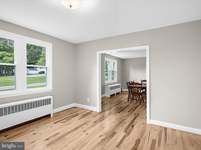 empty room with radiator and light wood-type flooring