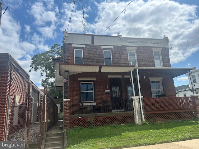 townhome / multi-family property featuring a front lawn and covered porch