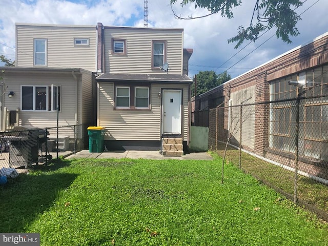 rear view of property with a lawn