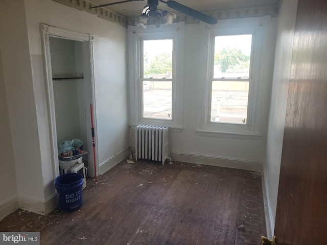 unfurnished bedroom with hardwood / wood-style flooring, ceiling fan, and radiator