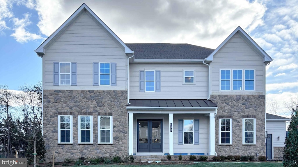 view of front of house featuring a shingled roof, metal roof, a standing seam roof, french doors, and a front lawn