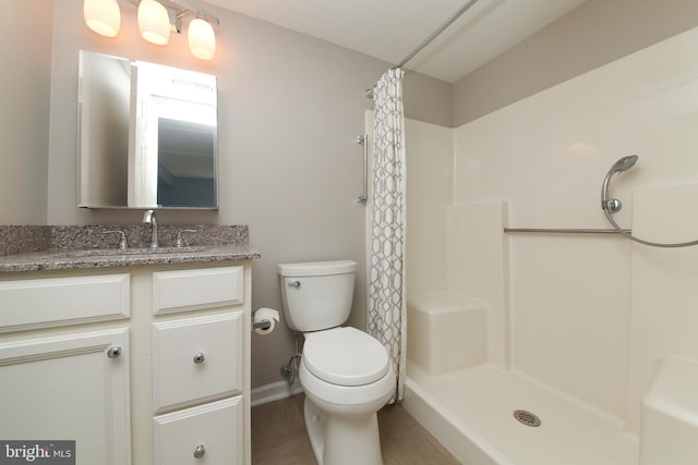 bathroom featuring a shower with shower curtain, toilet, and vanity