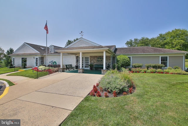 ranch-style house featuring a front yard and covered porch