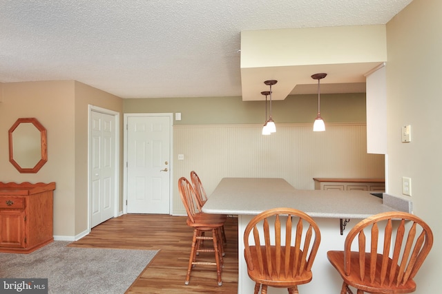 dining area with a textured ceiling and light wood-type flooring