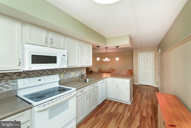 kitchen with light hardwood / wood-style flooring, white cabinets, sink, kitchen peninsula, and white appliances