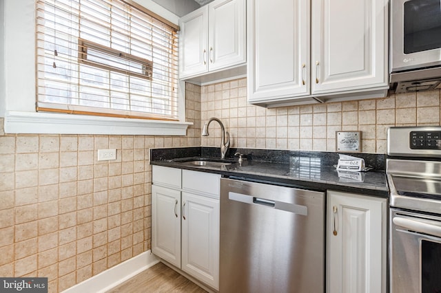 kitchen featuring appliances with stainless steel finishes, light hardwood / wood-style floors, white cabinetry, and sink