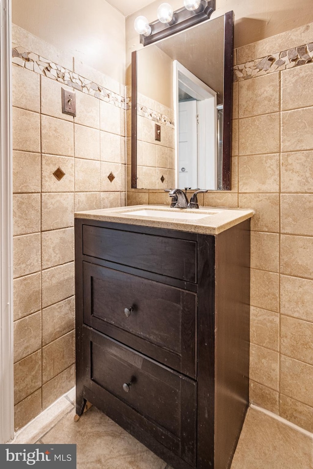 bathroom featuring vanity and tile walls