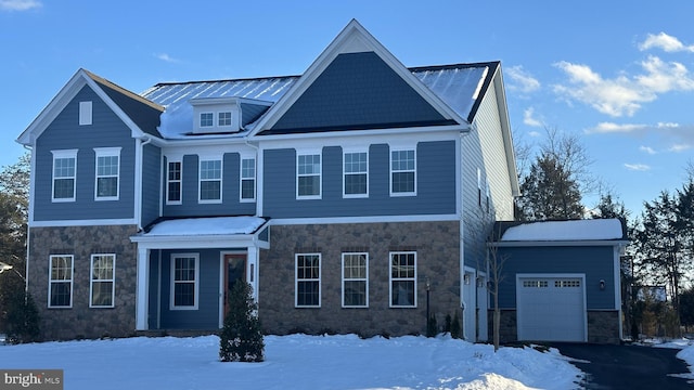 view of front of home with stone siding, driveway, and a garage