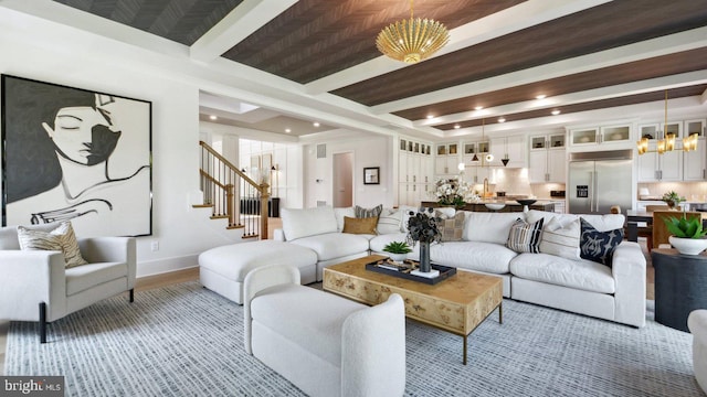 living room with beam ceiling and a notable chandelier