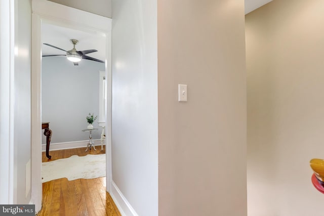 hallway with baseboards and wood finished floors