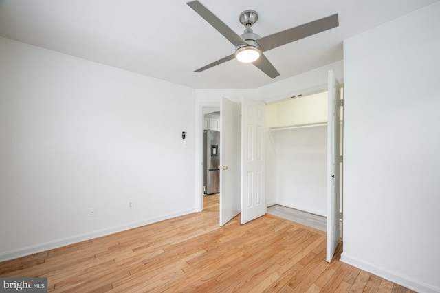 unfurnished bedroom with light hardwood / wood-style flooring, ceiling fan, a closet, and stainless steel refrigerator with ice dispenser