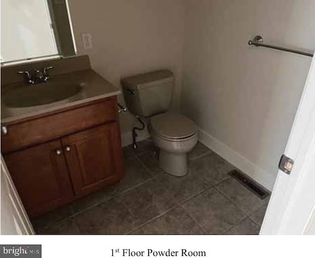 bathroom with tile patterned flooring, vanity, and toilet