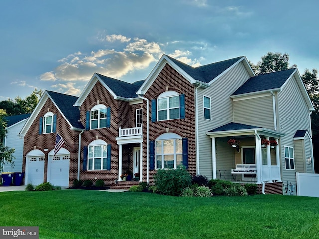 view of front of house featuring a garage, a front lawn, and covered porch