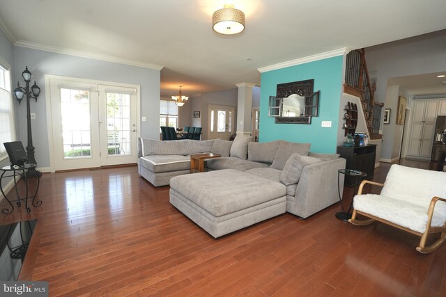 living area with baseboards, ornamental molding, wood finished floors, and ornate columns